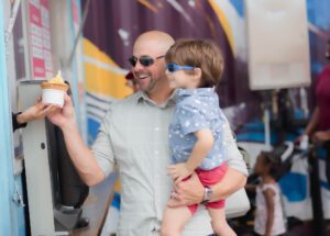 Caucasian father holding his boy, buying ice cream at Boxi park, Orlando, Florida