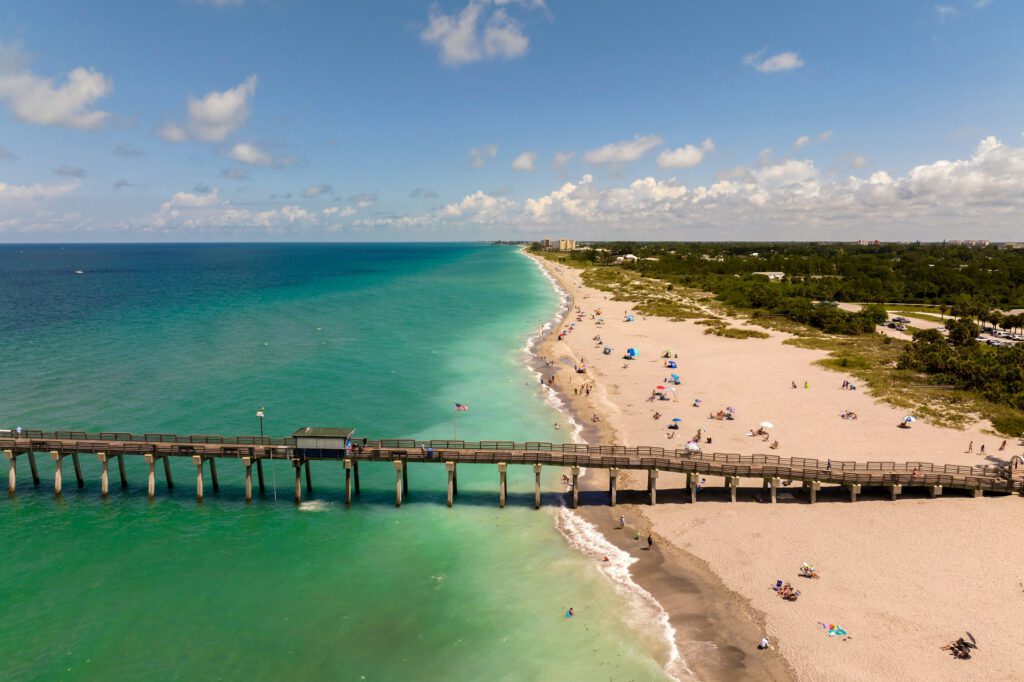 Venice fishing pier in Florida on sunny summer day. Bright seascape with surf waves